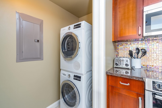 laundry room with stacked washer / dryer and electric panel