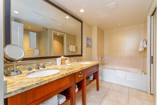 bathroom featuring tile patterned flooring, vanity, and a tub to relax in