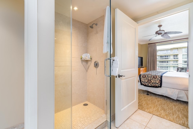 bathroom with tile patterned flooring, ceiling fan, and a shower with door