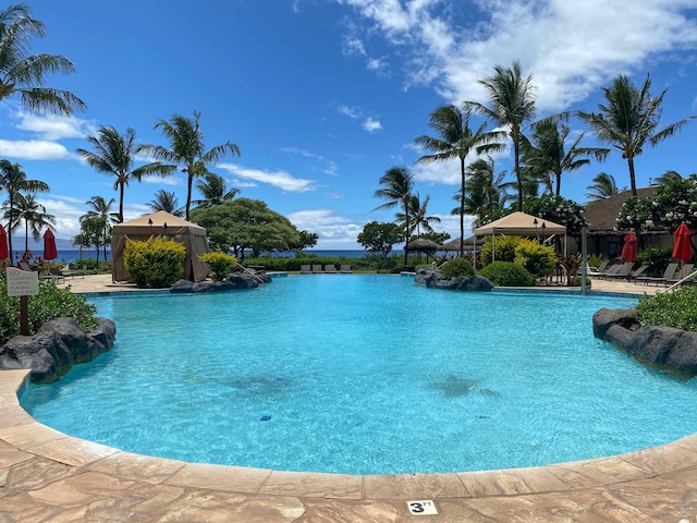 view of pool with a gazebo and a water view