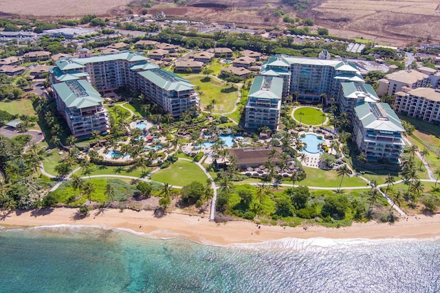 birds eye view of property featuring a water view and a beach view