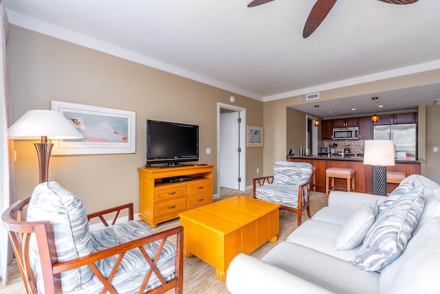 living room featuring light hardwood / wood-style floors, ceiling fan, and crown molding