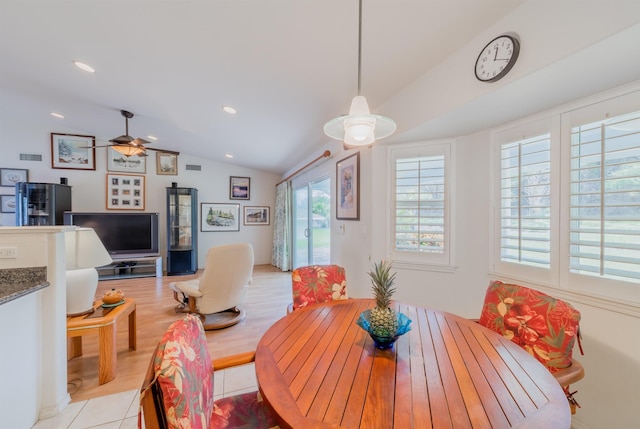 tiled dining room featuring ceiling fan and vaulted ceiling