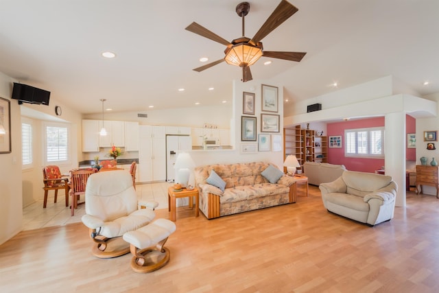 living room featuring lofted ceiling and light hardwood / wood-style floors