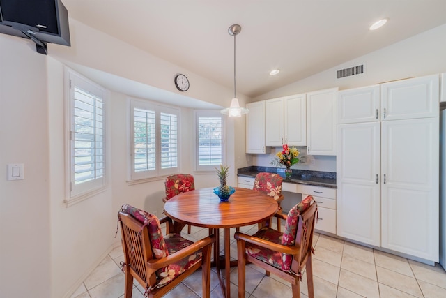 dining room featuring vaulted ceiling and light tile patterned floors