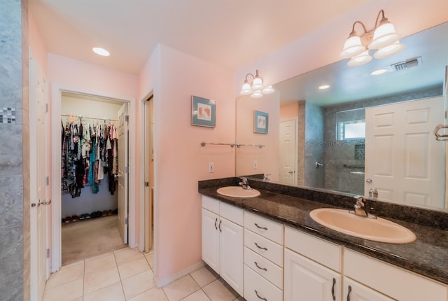 bathroom featuring tile patterned floors, vanity, and tiled shower