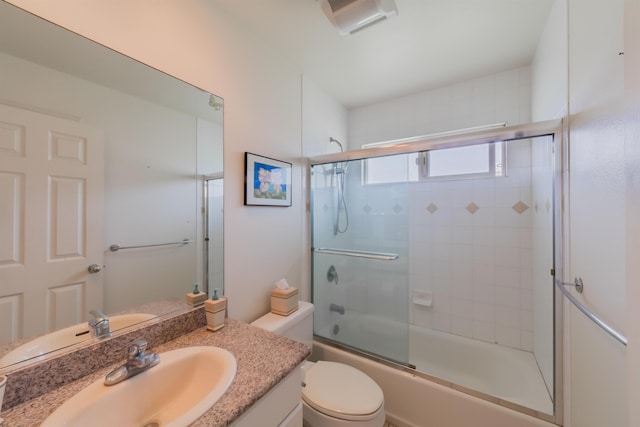 full bathroom with bath / shower combo with glass door, vanity, and toilet