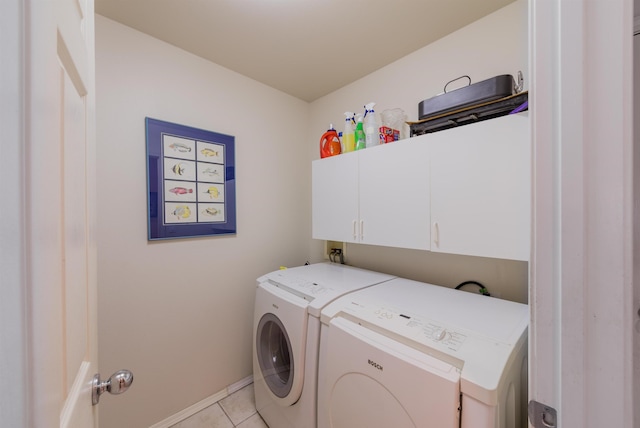 laundry area featuring light tile patterned floors, washing machine and dryer, and cabinets