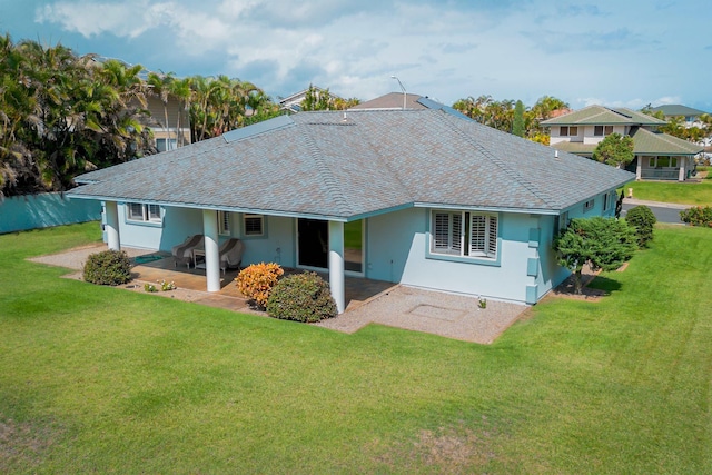 rear view of property with a yard and a patio area