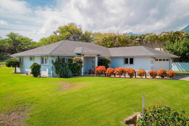 ranch-style house featuring a garage and a front lawn