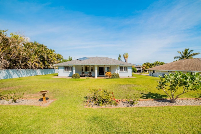 rear view of property featuring a lawn and a patio area