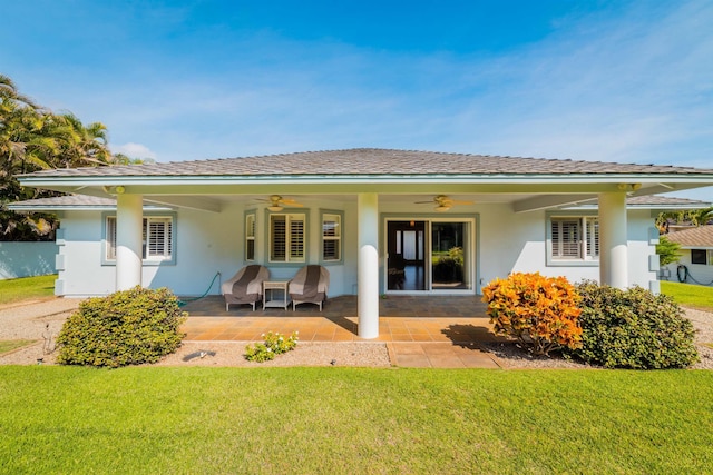 rear view of property featuring a patio area, ceiling fan, and a lawn