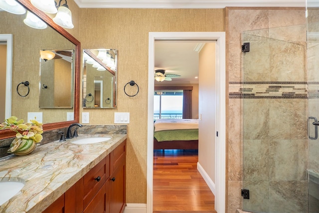 bathroom featuring hardwood / wood-style flooring, vanity, an enclosed shower, and crown molding