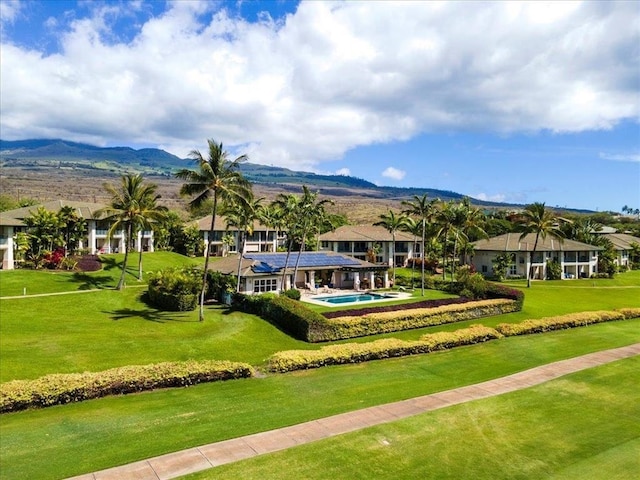 surrounding community with a swimming pool, a lawn, and a mountain view