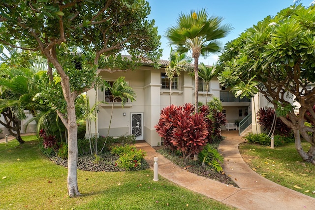 townhome / multi-family property featuring a front lawn and a balcony