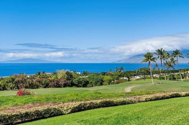 surrounding community featuring a water and mountain view and a lawn