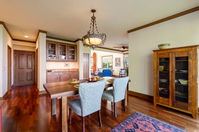 dining area featuring ceiling fan, dark hardwood / wood-style flooring, and crown molding