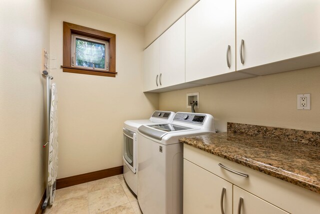 laundry room with washing machine and clothes dryer and cabinets