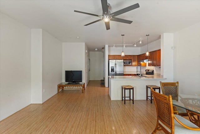 31 E Kuu Aku Ln Unit 206, Lahaina, HI 96761 - kitchen featuring stainless steel appliances, light wood-style floors, a peninsula, a ceiling fan, and light countertops