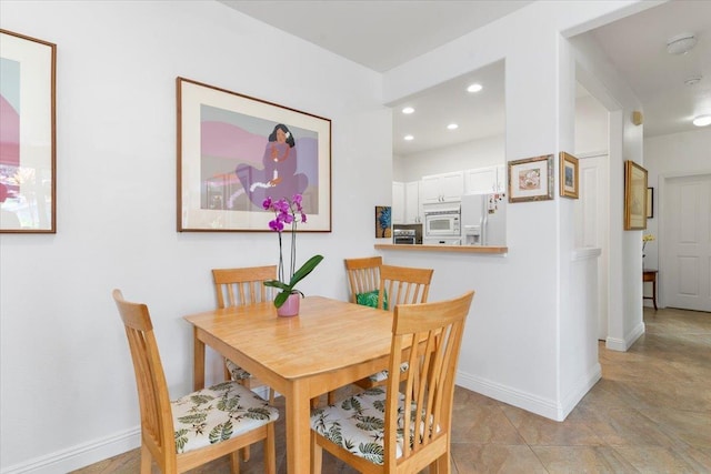 dining room with baseboards and recessed lighting