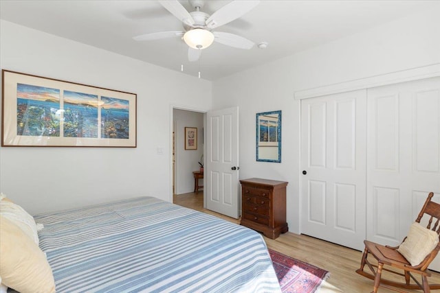 bedroom featuring light wood-style floors, ceiling fan, and a closet