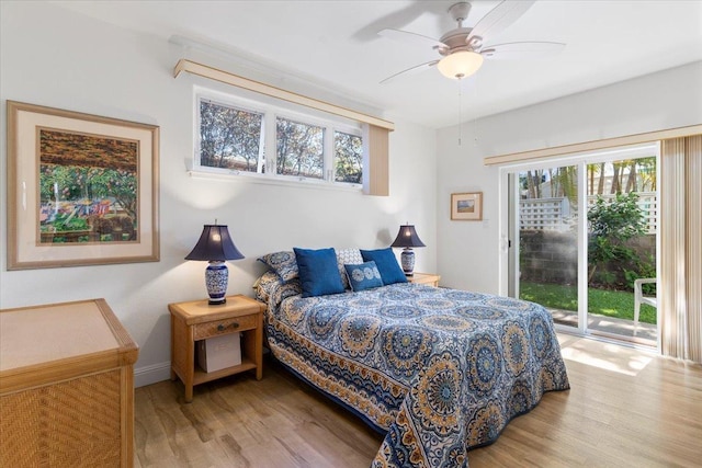 bedroom featuring a ceiling fan, access to outside, baseboards, and wood finished floors