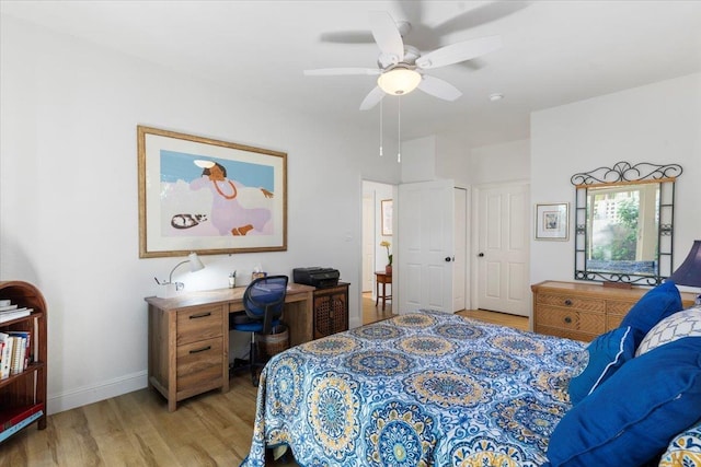 bedroom with light wood-type flooring, ceiling fan, and baseboards