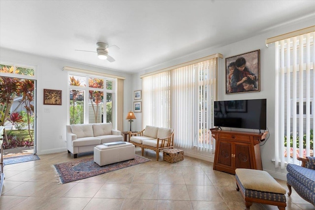 interior space featuring a ceiling fan, baseboards, and light tile patterned floors