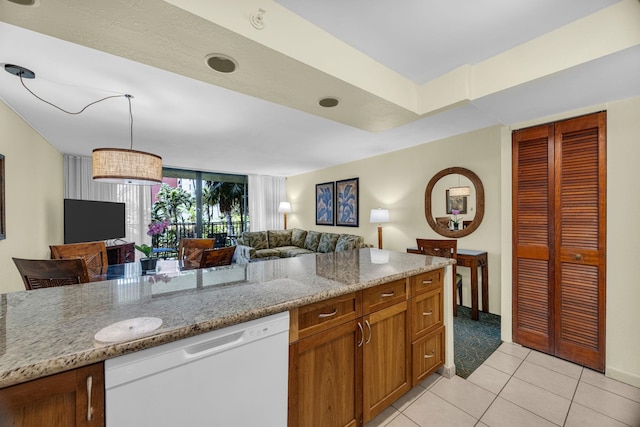 kitchen with brown cabinetry, light stone countertops, white dishwasher, open floor plan, and light tile patterned floors