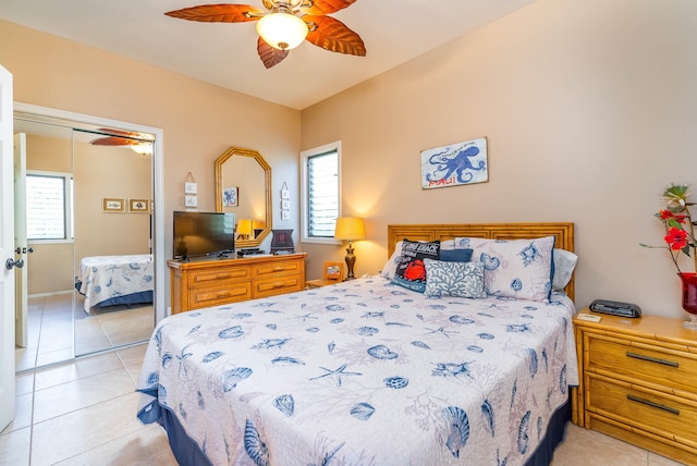 tiled bedroom with multiple windows, ceiling fan, and a closet