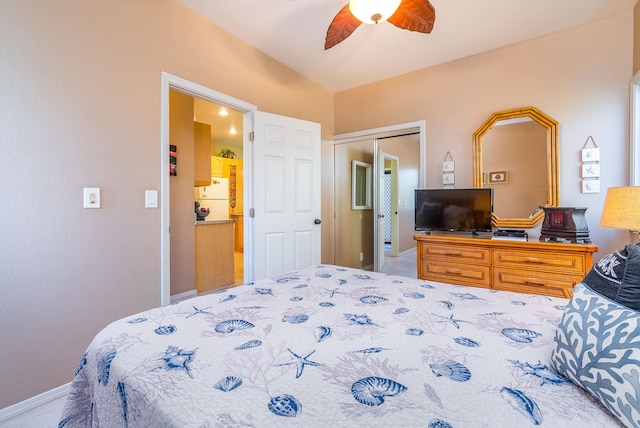 carpeted bedroom with ceiling fan, a closet, and white refrigerator