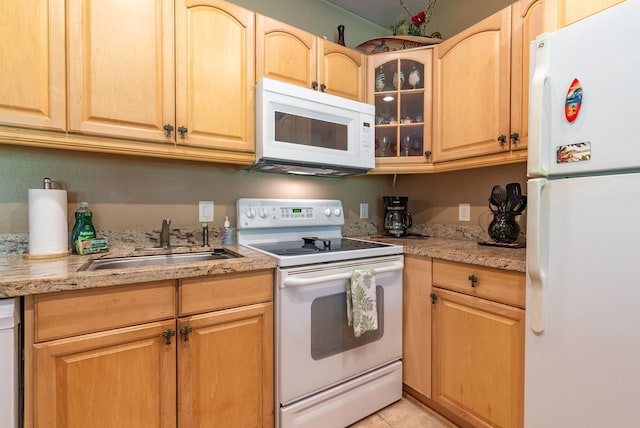 kitchen with light stone countertops, light brown cabinetry, white appliances, sink, and light tile patterned flooring