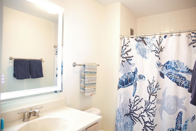 bathroom with vanity, toilet, and curtained shower