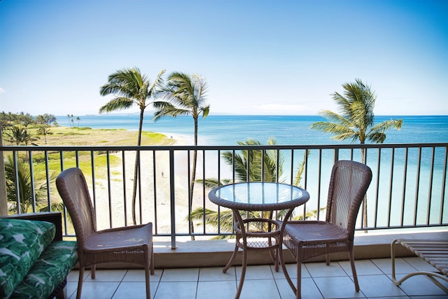 balcony with a water view and a view of the beach