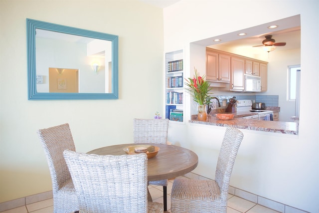 tiled dining space featuring ceiling fan