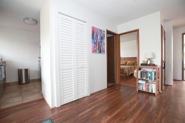 hall with dark hardwood / wood-style flooring and a textured ceiling