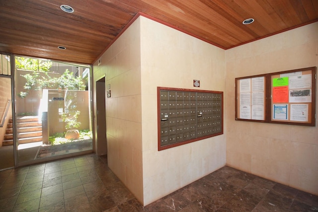 interior space with tile walls, wood ceiling, and a mail area