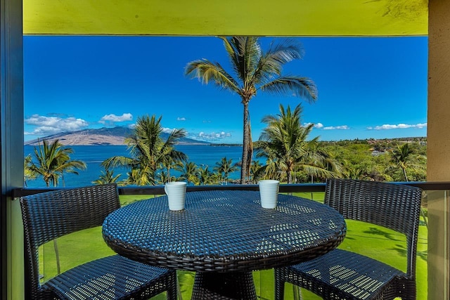 balcony featuring a water and mountain view