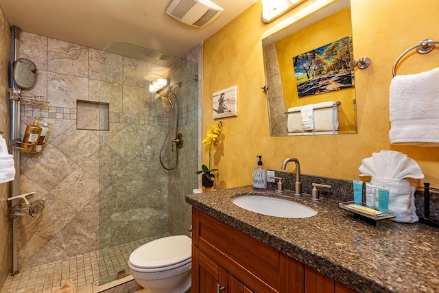 bathroom with toilet, visible vents, a walk in shower, and vanity