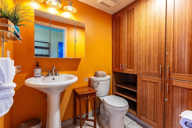 half bathroom featuring tile patterned floors, visible vents, and toilet