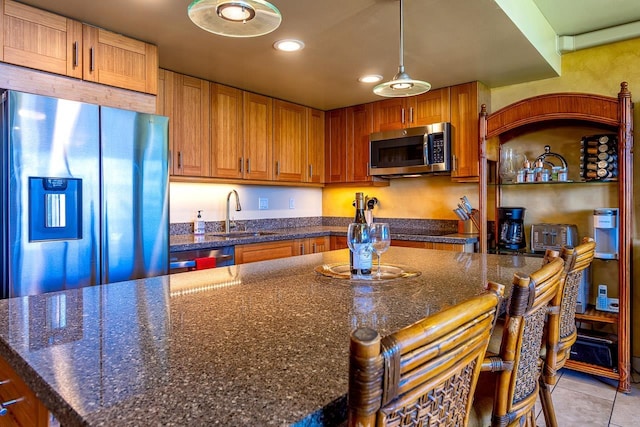 kitchen featuring recessed lighting, a sink, brown cabinets, stainless steel appliances, and light tile patterned flooring
