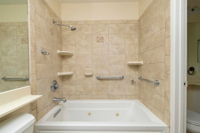 bathroom with tiled shower / bath combo and toilet