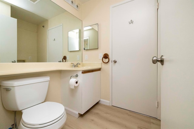 bathroom with hardwood / wood-style flooring, vanity, and toilet