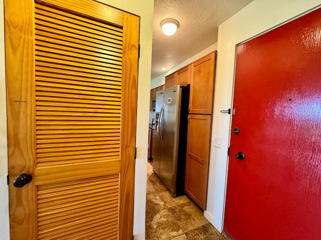 corridor featuring dark tile flooring and a textured ceiling