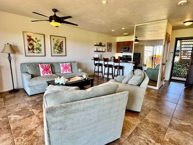 tiled living room with ceiling fan and a textured ceiling