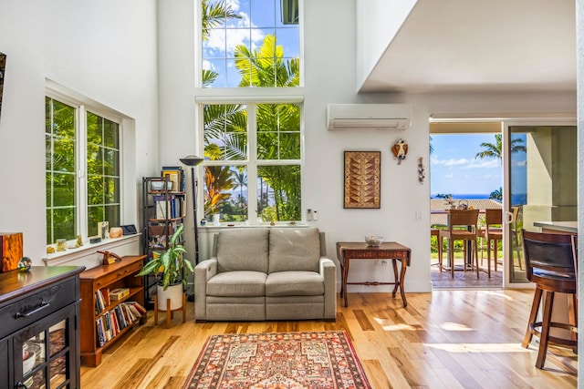 sunroom / solarium featuring a wall mounted air conditioner and a wealth of natural light