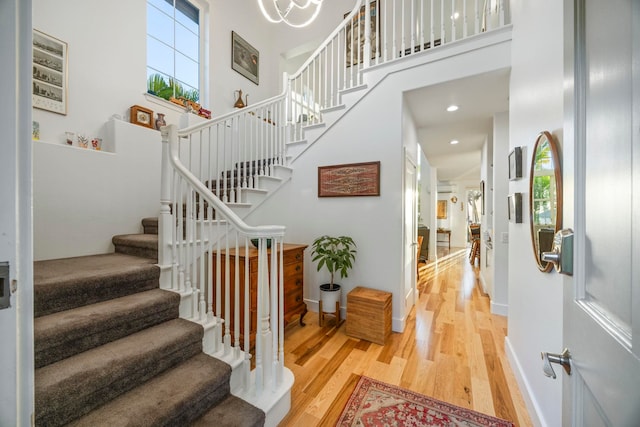 foyer entrance featuring hardwood / wood-style floors and a towering ceiling