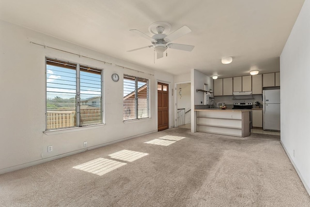 unfurnished living room with ceiling fan and light colored carpet