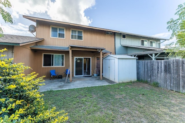 back of property featuring a patio, a yard, and a storage unit