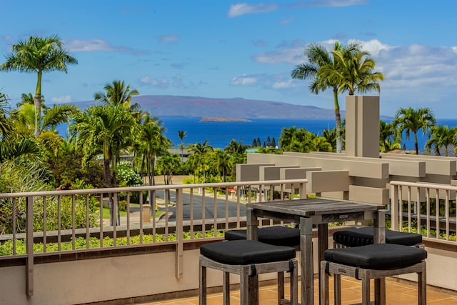 balcony featuring a water and mountain view